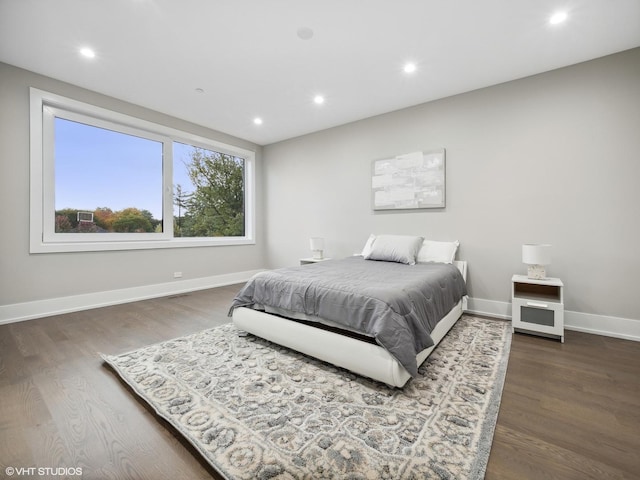 bedroom with dark hardwood / wood-style flooring