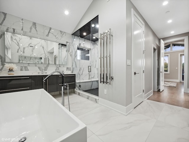 bathroom with vanity, shower with separate bathtub, and vaulted ceiling