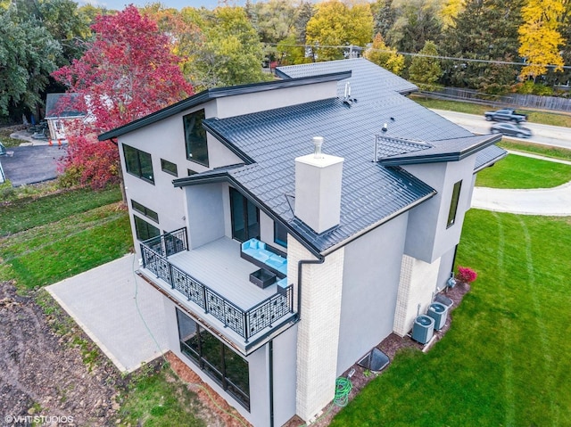 rear view of property with a yard and central air condition unit