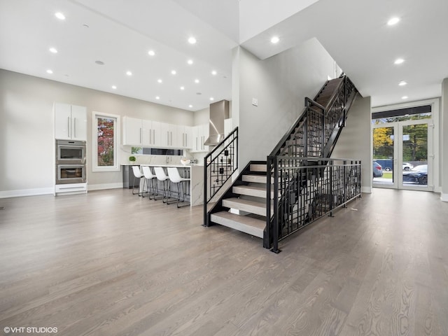 stairs with hardwood / wood-style floors and a wealth of natural light