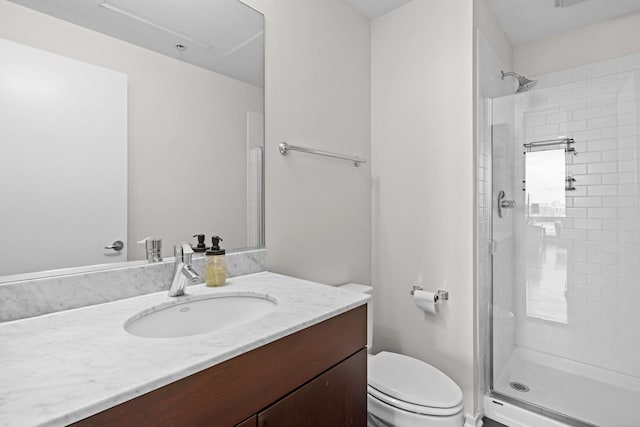 bathroom with a shower with door, vanity, and toilet