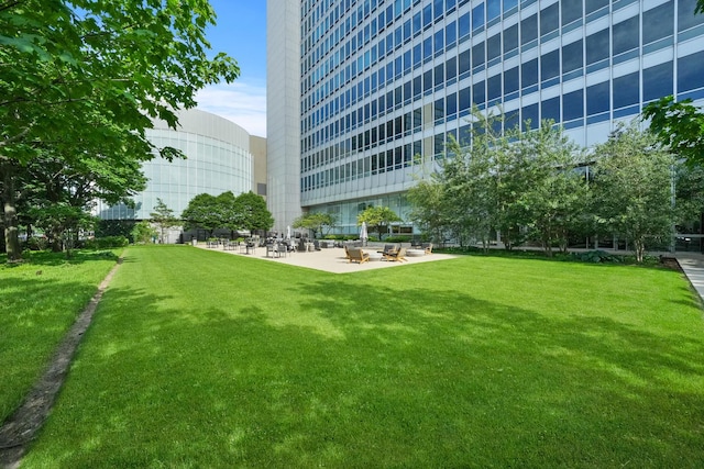 view of community featuring a lawn and a patio