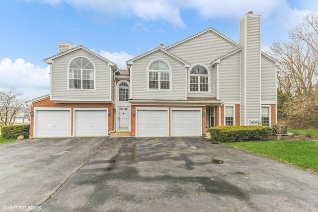 814 Kalamazoo Cir, Vernon Hills, IL 60061 - view of front of property with brick siding, driveway, a garage, and a chimney
