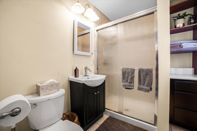 bathroom featuring vanity, toilet, a shower with shower door, and tile patterned flooring