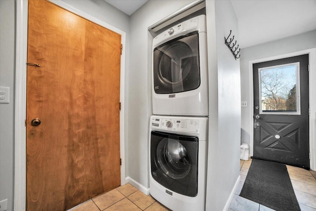 laundry room featuring light tile patterned flooring and stacked washer / drying machine