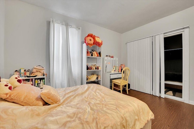 bedroom with dark hardwood / wood-style floors and access to exterior