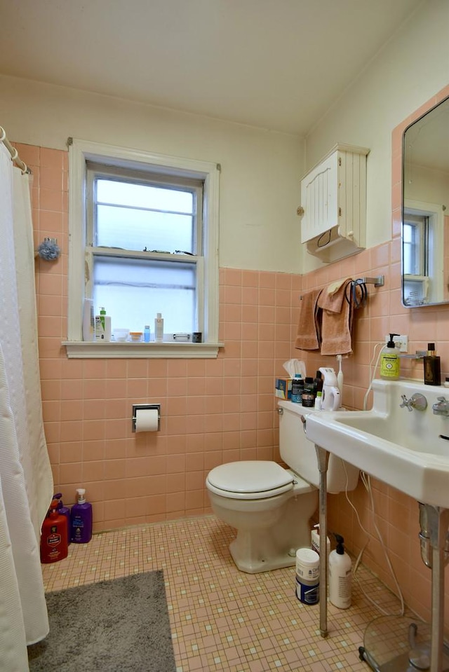 bathroom with tile patterned flooring, tile walls, and toilet