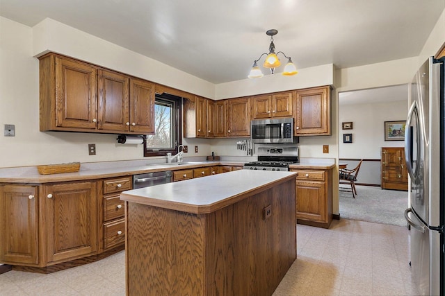 kitchen featuring pendant lighting, sink, appliances with stainless steel finishes, an inviting chandelier, and a kitchen island