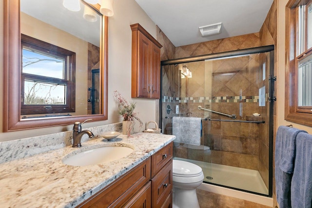 bathroom featuring vanity, toilet, and an enclosed shower