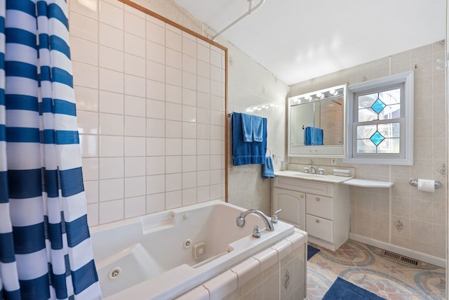 full bath with visible vents, vanity, and tile walls