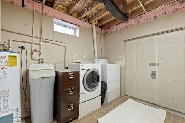 washroom with laundry area, water heater, and washer and dryer