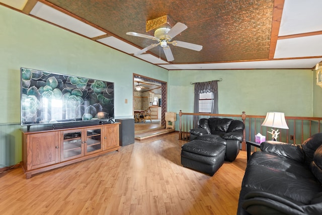 living area with a wainscoted wall, ceiling fan, and light wood-type flooring