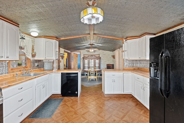 kitchen with a peninsula, black appliances, vaulted ceiling with beams, and a sink