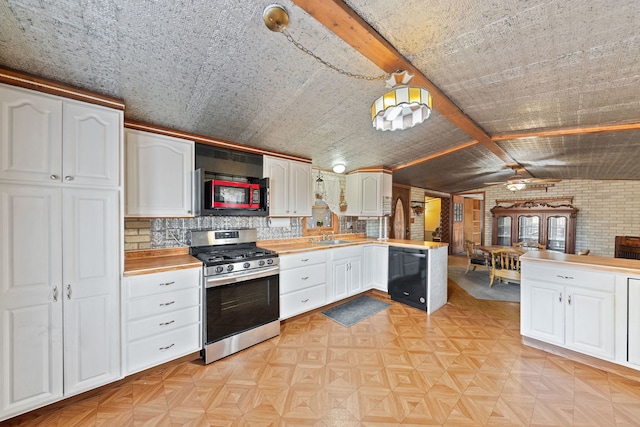 kitchen with gas stove, black dishwasher, white cabinets, and vaulted ceiling with beams