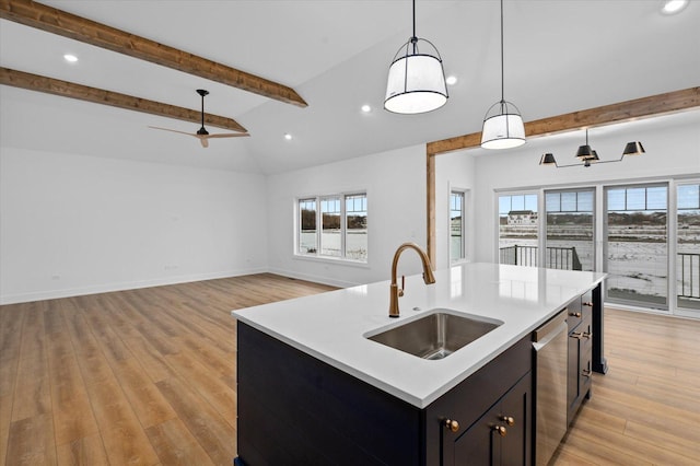 kitchen featuring sink, dishwasher, hanging light fixtures, lofted ceiling with beams, and a center island with sink