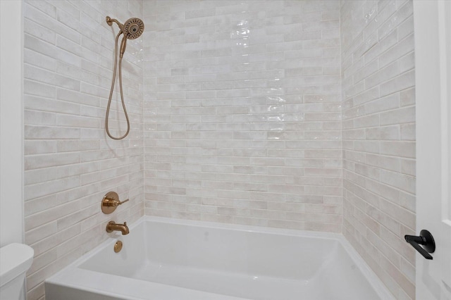 bathroom featuring tiled shower / bath combo and toilet