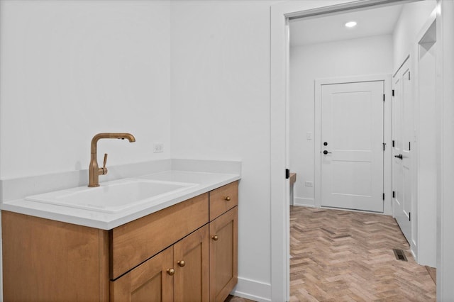 bathroom featuring parquet flooring and vanity