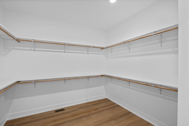 walk in closet with hardwood / wood-style flooring