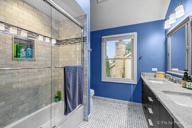 full bathroom featuring vanity, bath / shower combo with glass door, and toilet