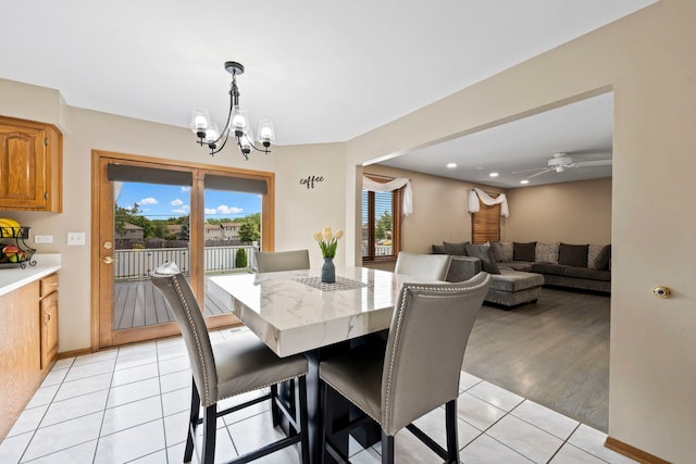 dining space featuring ceiling fan with notable chandelier, plenty of natural light, and light tile patterned flooring