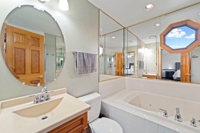 bathroom with vanity, toilet, and tiled bath