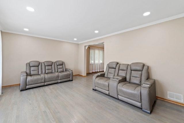 living room with crown molding and light hardwood / wood-style flooring