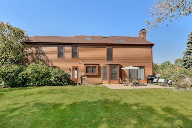 back of property with a yard and a patio area