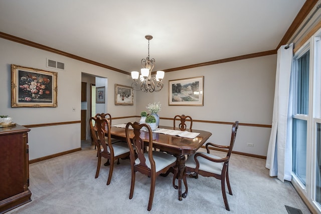 carpeted dining space with crown molding and an inviting chandelier