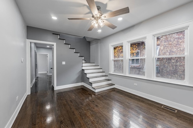 stairway with ceiling fan and wood-type flooring