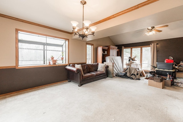 carpeted living area featuring lofted ceiling, ornamental molding, ceiling fan with notable chandelier, and baseboards