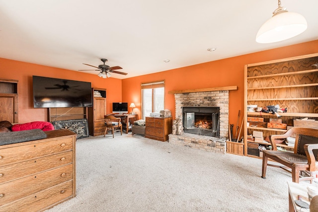 living area with carpet floors, a fireplace, and a ceiling fan