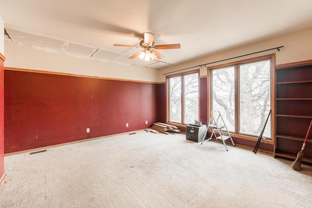 empty room with a ceiling fan, carpet, and visible vents