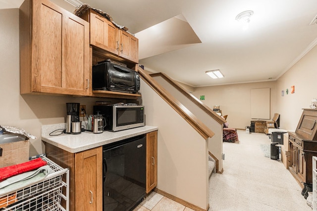 kitchen featuring black microwave, light countertops, ornamental molding, fridge, and stainless steel microwave