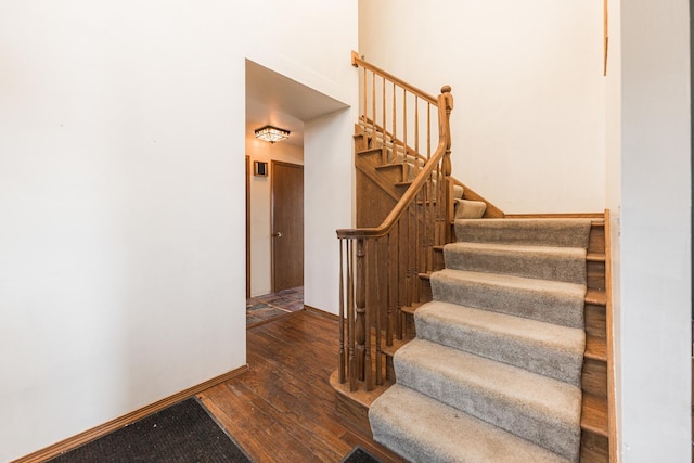 stairway with hardwood / wood-style flooring and baseboards