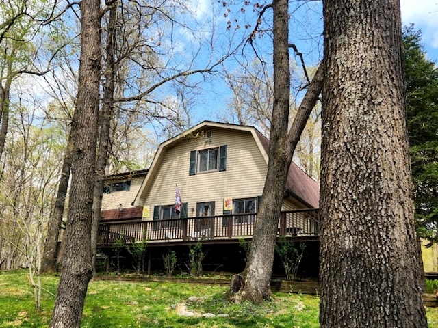 rear view of property featuring a yard and a deck