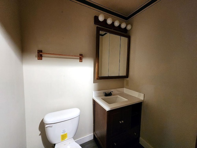 bathroom with crown molding, vanity, and toilet