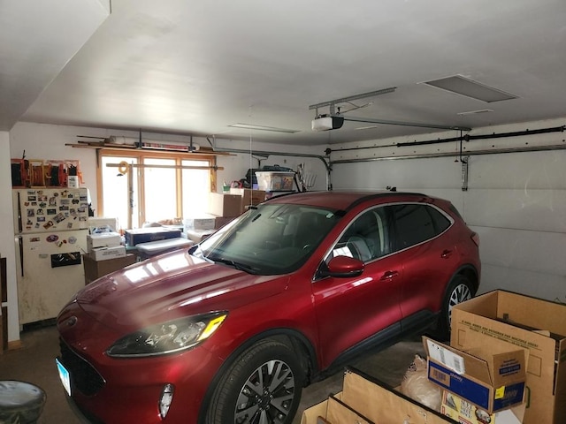 garage featuring a garage door opener and white fridge