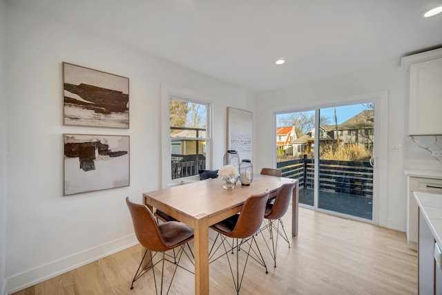 dining area with light hardwood / wood-style floors and a healthy amount of sunlight