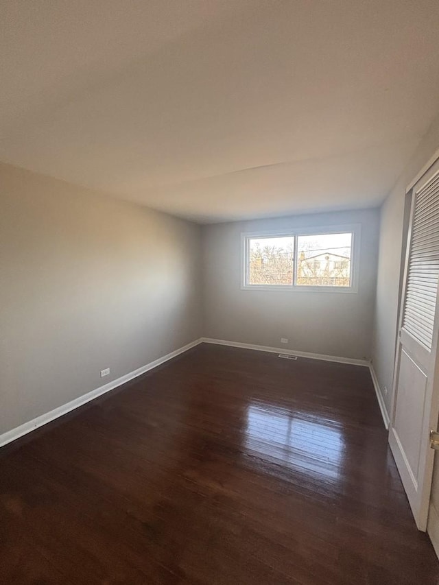 spare room with dark hardwood / wood-style flooring