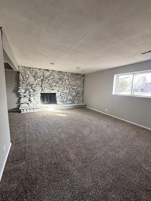 unfurnished living room featuring carpet flooring, a fireplace, and a textured ceiling