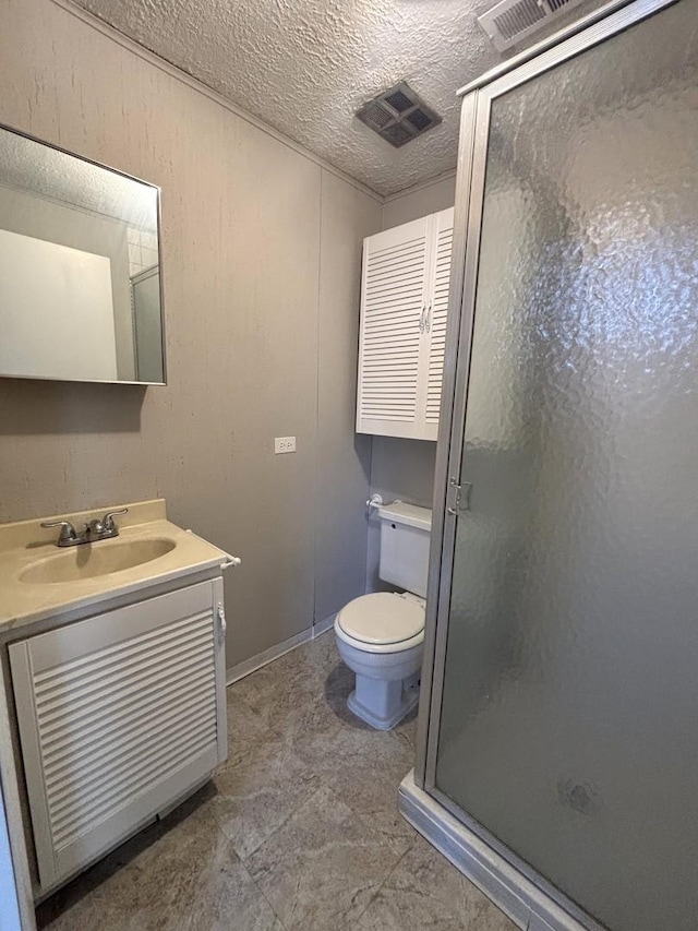 bathroom with vanity, an enclosed shower, a textured ceiling, and toilet