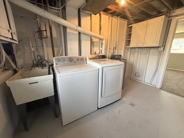 laundry room featuring sink, washing machine and dryer, and cabinets