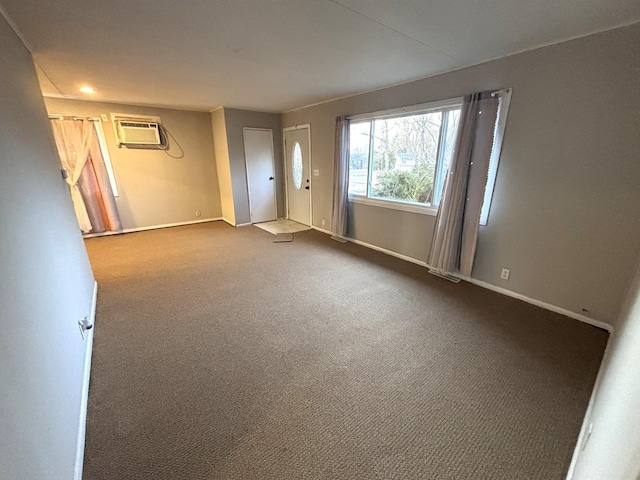 empty room featuring a wall mounted air conditioner and carpet