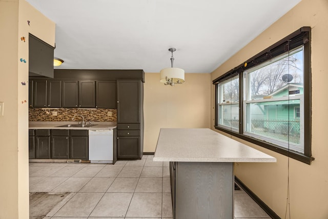 kitchen with a kitchen island, decorative light fixtures, dishwasher, sink, and decorative backsplash