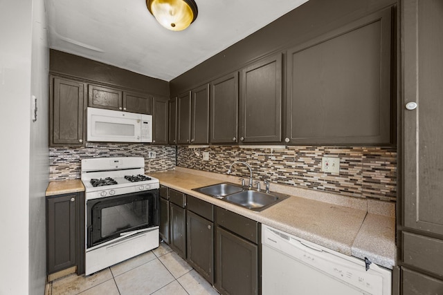 kitchen featuring dark brown cabinetry, sink, light tile patterned floors, white appliances, and decorative backsplash