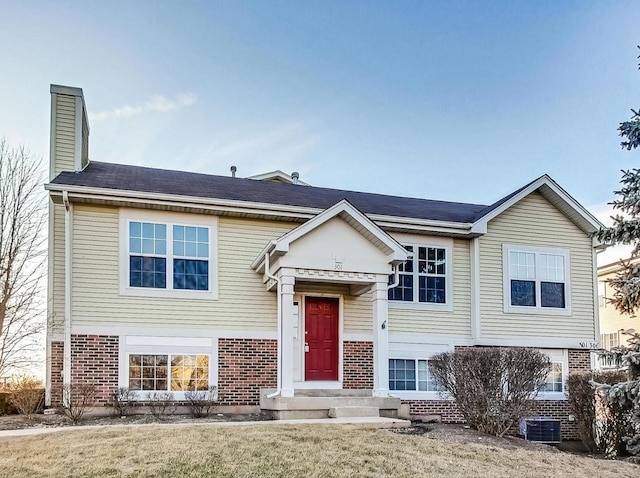 bi-level home featuring central AC and a front yard