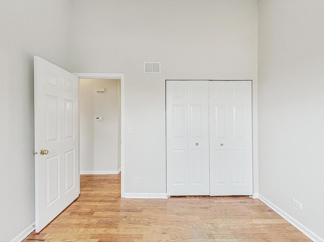 unfurnished bedroom with light hardwood / wood-style floors and a closet