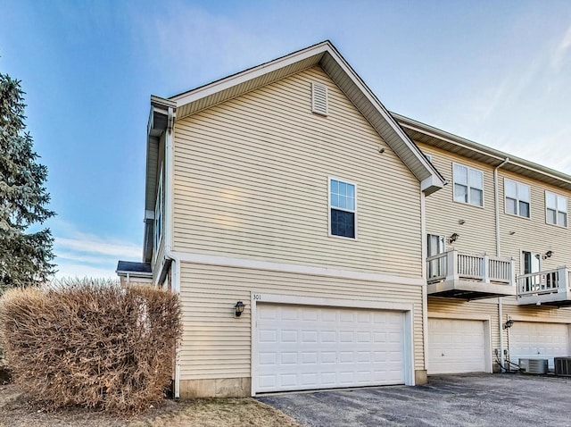 view of property exterior with cooling unit and a garage