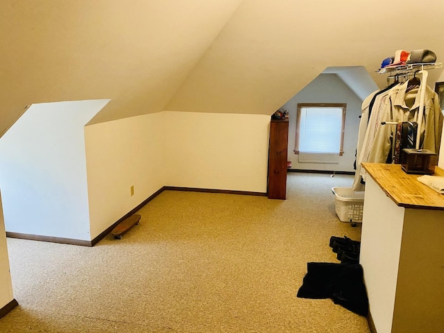 bonus room featuring vaulted ceiling and carpet