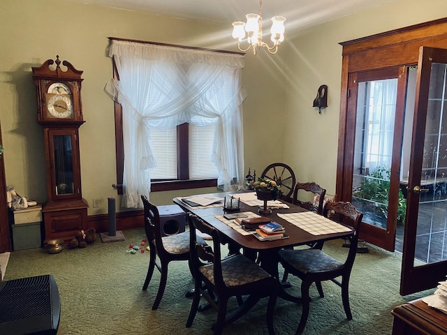 dining space with carpet and an inviting chandelier